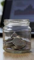Time lapse money coin in a glass jar grows on the background of financial charts. Concept financial business investment. Close-up, Vertical footage video