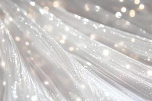 A close-up of flowing white fabric with sparkling glitter and soft bokeh lights, creating a dreamy and elegant atmosphere. photo