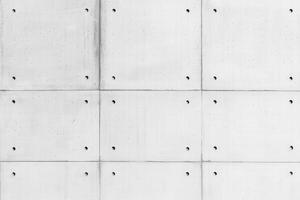 Seamless textured concrete wall with a grid pattern and small holes. photo