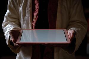 A person holding a tablet computer with a blank screen photo