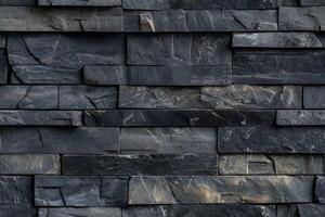 Textured artesia stone cladding wall made of dark slate tiles, showcasing various shades of gray and subtle gold veining. photo