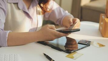 A woman using a cell phone and a credit card video