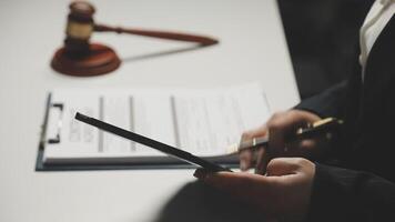 A judge's gavel is in the background of a business person's hands video