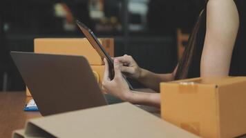 en kvinna är använder sig av en bärbar dator och en läsplatta medan Sammanträde på en tabell med lådor video