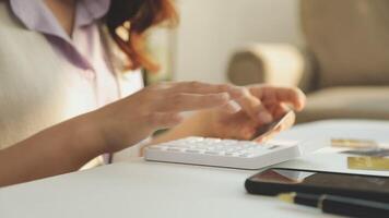 A woman is using a calculator to make a payment video