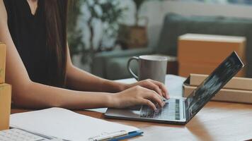 A woman typing on her laptop while surrounded by boxes video