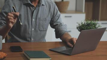 A man is working on his laptop at a table video