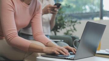 A woman is typing on a laptop while sitting on a couch video