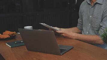 Man using a tablet while sitting at a table video