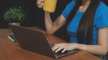 A woman is sitting at a table with a laptop and a mug of coffee video