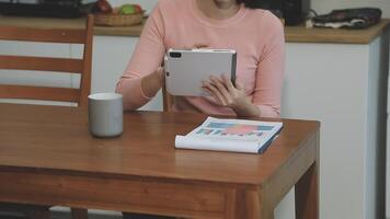 A woman sitting at a table with a tablet computer video