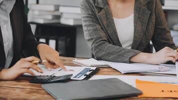 Two business people at a table with paperwork and papers video
