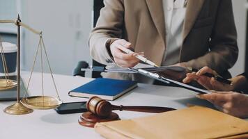 A lawyer and a client at a desk with a scale and a pen video