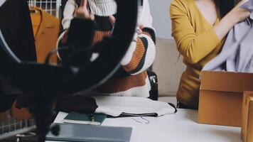 Two women are looking at a camera while sitting on a table video