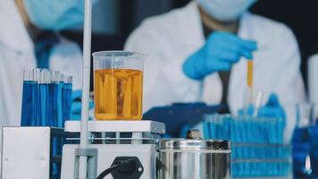 Scientists in lab coats and gloves working with test tubes video
