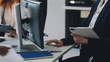 A woman is using a computer and a man is sitting at a desk video