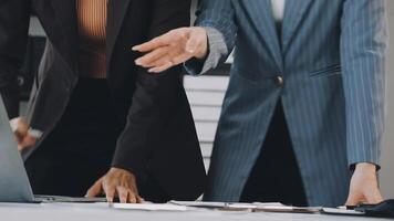 Two business people are talking and one is pointing at a laptop video