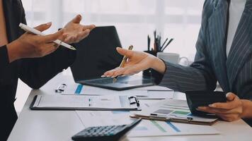 Two business people talking at a table with paperwork video