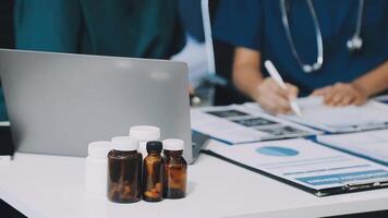 Two doctors working on a laptop and bottles video