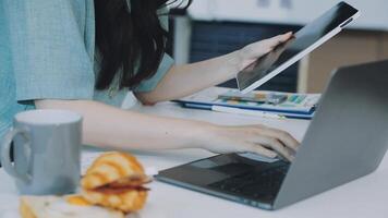 A woman using a laptop and a croissant video