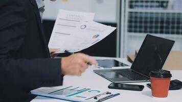 A man in a suit is holding a document and looking at it video