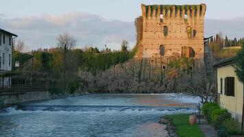 A river running through a town with a castle in the background video