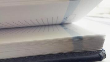 Flipping pages in a notebook or planner, side view showing the texture of the paper video
