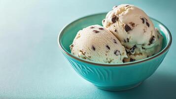 Delightful scoops of chocolate chip ice cream in teal bowl, refreshing and sweet treat photo