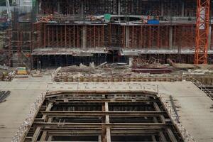 The workers work in the building under construction with many scaffolding inside photo