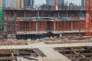 The workers work in the building under construction with many scaffolding photo