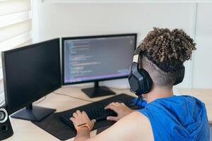 Software engineer sitting at desk and typing on computer keyboard while creating code while working at home. photo