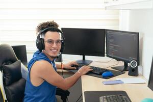 Young male programmer in casual clothes working on the computer at the table. photo