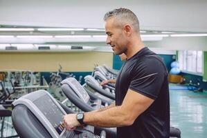 Man setting control panel of treadmill for training photo