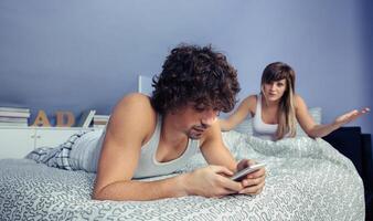Man using smartphone in quarrel with woman photo