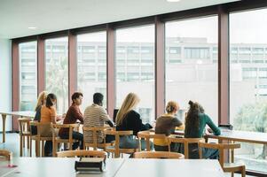Diverse classmates studying near window photo
