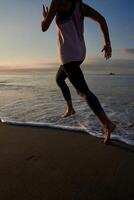 Anonymous woman running on seacoast at sundown time photo