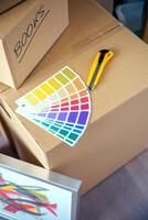 Detail of color palette and cutter over moving boxes photo