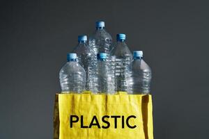 Plastic bottles in yellow bag for recycling photo