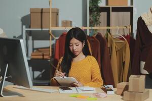 A woman is sitting at a desk with a tablet photo