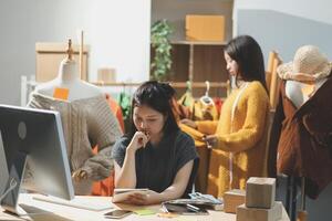 Two women are working at a desk in an office photo