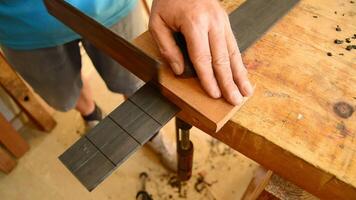 Luthier making the frets of a guitar with a hacksaw video