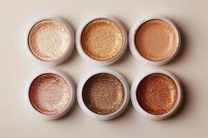 Six shimmering metallic eyeshadow pots in earth tone shades, creating a captivating arrangement photo