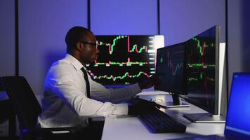 Stock trader analyzing market charts on multiple monitors video