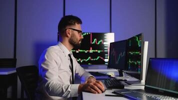 Stock trader analyzing financial charts on multiple screens video