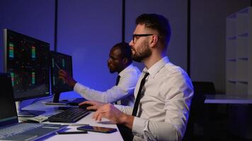 Two traders analyzing stock market data on multiple screens video