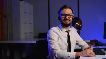 Smiling call center operator assisting customers remotely video