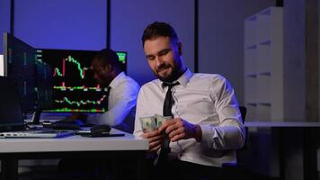 Happy stock trader counting cash after successful investment video