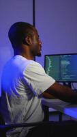 Focused programmer coding on multiple screens at night video