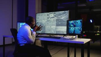 Security officer monitoring CCTV and giving instructions via radio video