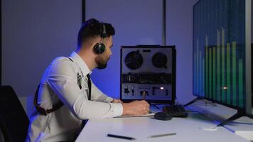 Intelligence officer analyzing intercepted audio and taking notes video